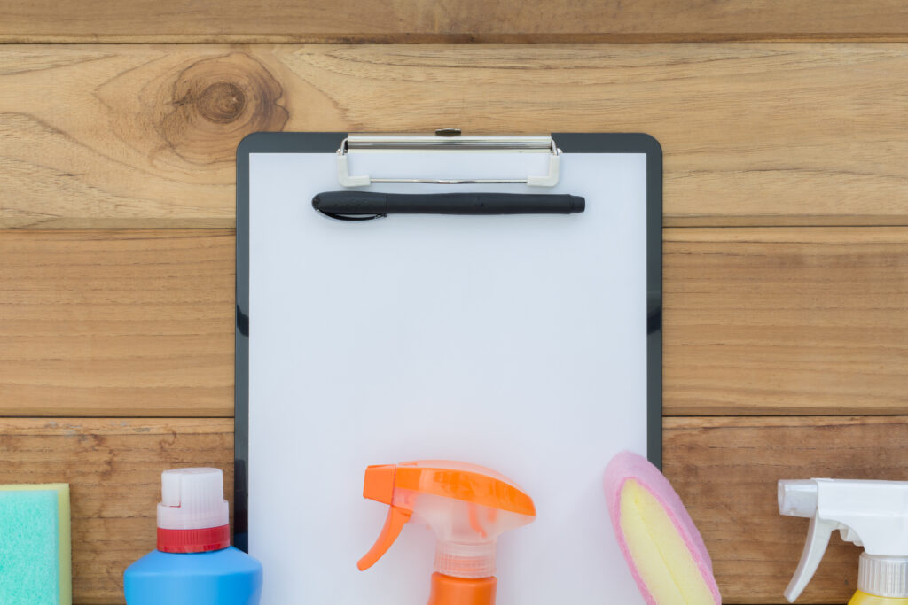 Cleaning clipboard list with house clean product on wood table